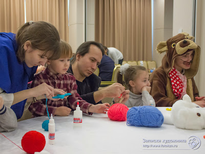 Дети, родители и сказочные персонажи плетут из ниток