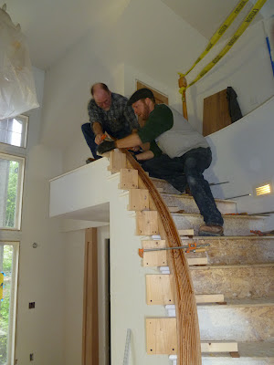Shawn Christman and Christian leach laminate a custom profiled curved cherry handrail.