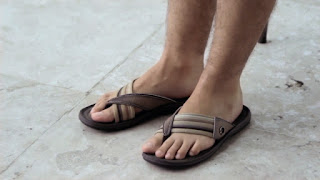 Os pés masculinos do Thiago Lacerda em chinelos Cartago