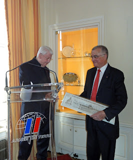 Le lauréat Pierre Darcourt remet le chèque de 6000 euros qu'il vient de recevoir au général Bernard Thorette, président de l'association Terre Fraternité.