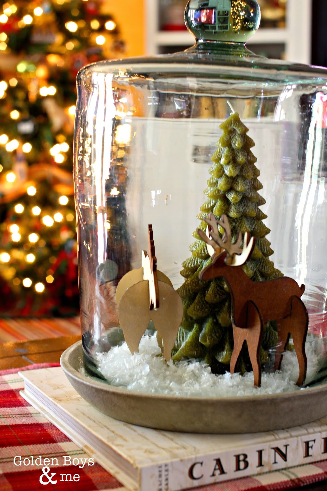 Wooden moose and deer with pine tree candle in rustic cloche in Christmas family room-www.goldenboysandme.com