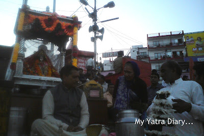 Priests sitting on raised wooden planks and performing certain rituals at the Har Ki Pauri Ghat in Haridwar