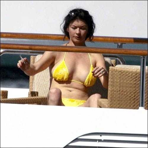 Catherine Zeta-Jones Yellow Bikini Candids while sunbath on the beach
