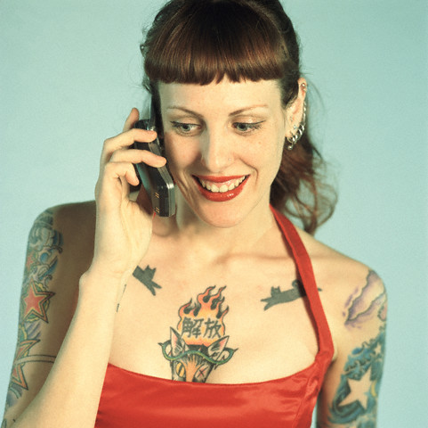 A woman on the phone with star tattoo on her sleeve
