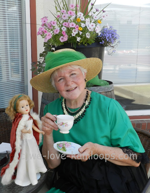 Val poses with a cup and her doll