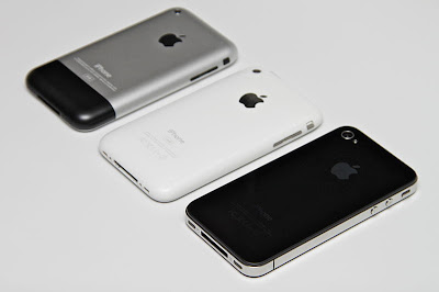 Three generations of iPhone, shown from behind. Left to right: original, white 3GS, black 4.