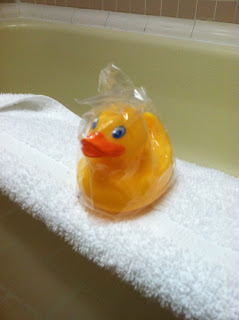 a yellow rubber duck on a white towel