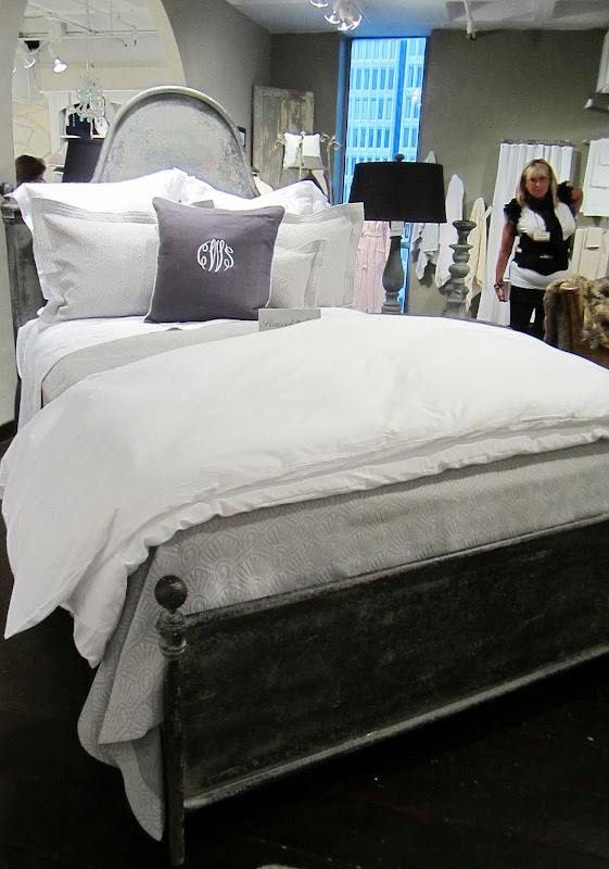 bed from Peacock Alley with grey and white bedding on an iron bed frame