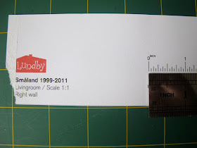 Ruler measuring a guide on a piece of paper printed with 'Lundby Smaland 1999-2001 Livingroom/ Scale 1:1'