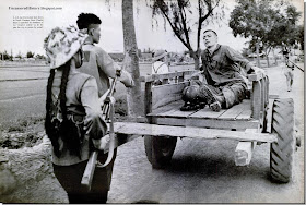 North Vietnam militia escorts American prisoner bullock cart