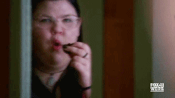 girl with glasses eating a piece of cake