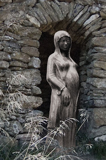 Vierge debout, tête voilée, elle est enceinte