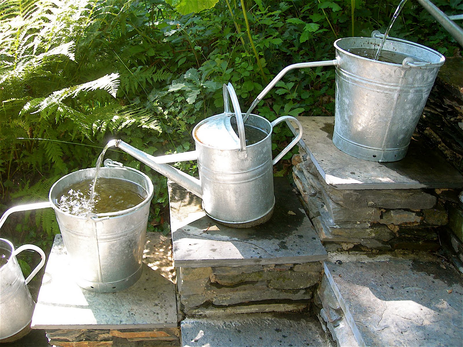 Pilgrim and Pie in France. Water feature with watering cans