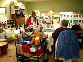 Two women at the table in a miniatures studio.
