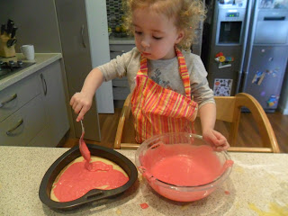 Spooning cake mix into tin for Rainbow Cake. Spooning cake mix into tin for Rainbow Cake.
