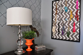 Pops of orange on the nightstand of this master bedroom along with the fun necklace organizer :: OrganizingMadeFun.com