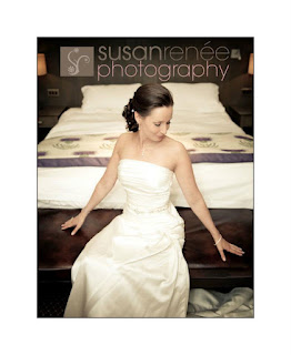 Bride reclining on end of bed with wedding dress