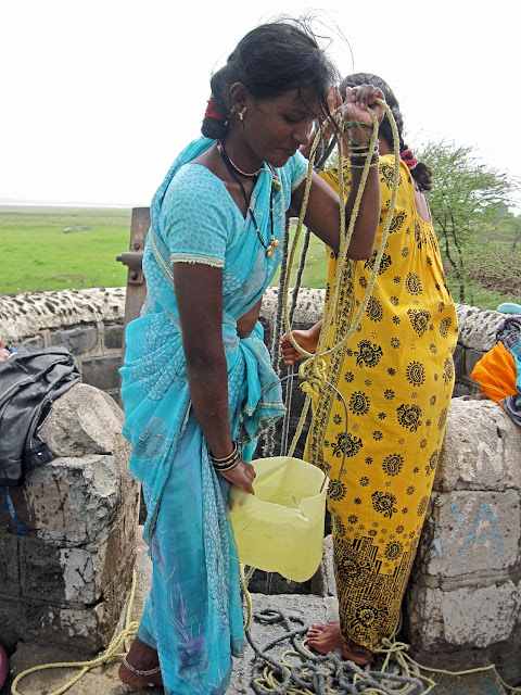 women drawing water from well