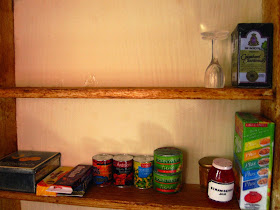 A selection of modern miniature groceries arranged on shelves.