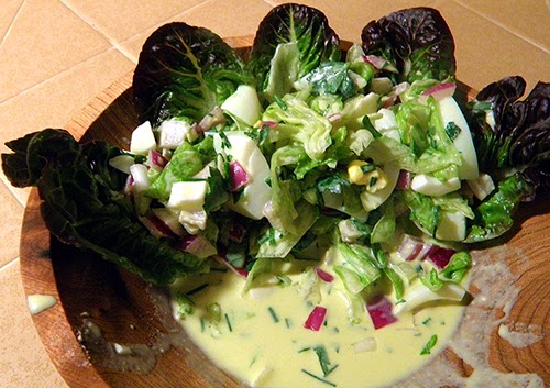 Half of Salad in a Large Serving Bowl with Large Amount of Dressing