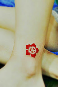 bright red totem flower tattoo on the ankle