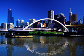 a bridge over a river with a city in the background