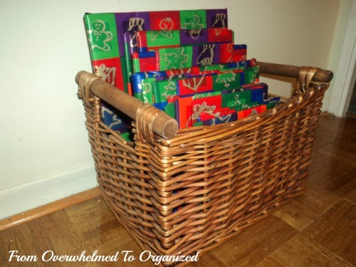 Basket of books wrapped in Christmas themed paper.