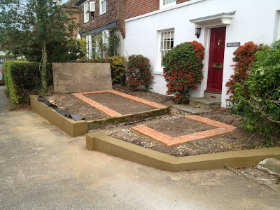 Recently cleared front garden with freshly rendered wall