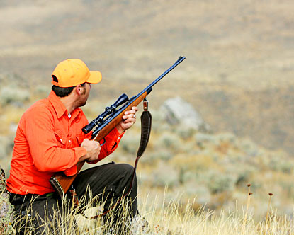 O caçador mira com um rifle. um homem camuflado está se preparando para  atirar. caçando na floresta com um rifle de precisão