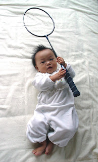 バドミントンラケットを持った赤ちゃんの写真