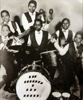 O Jackson Five: Marlon, Tito, Jackie, Jermaine, Michael e, com Johnny Jackson (nenhum parentesco) na bateria A Banda Completa e um Convidado Especial
