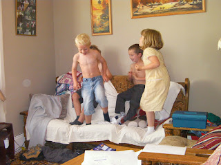 topless kids jumping off the sofa game using lounge as a playroom