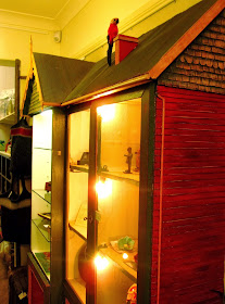 Display cabinet in the shape of a large dolls house