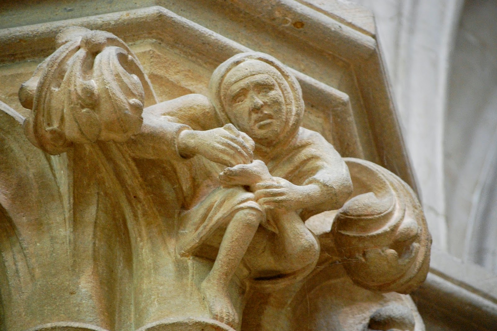 Carving of peasant with thorn in foot