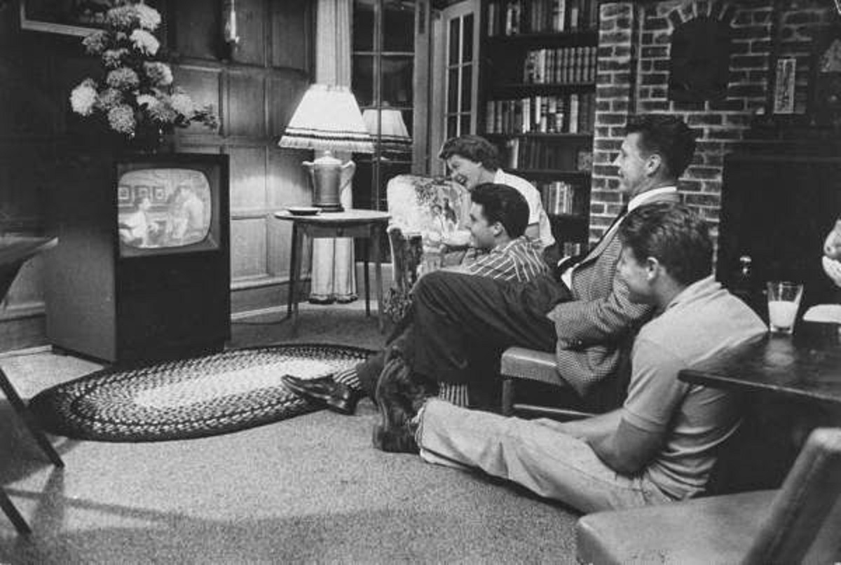 The Nelson family gather around the TV to watch an episode of their show. 1959.