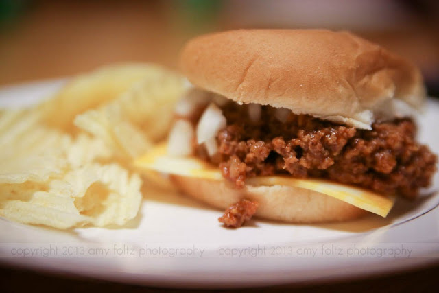 sloppy joes on a bun with a side of chips