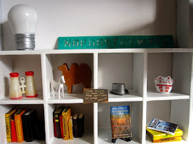 Decor items on a bookcase in a modern dolls' house miniature pop-up Little Library, 