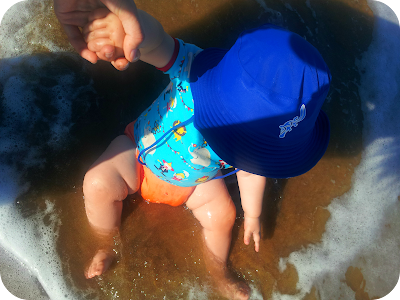 baby sat in the sea, baby enjoying the beach