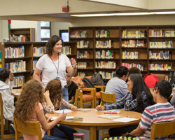Teacher working with students in Library.