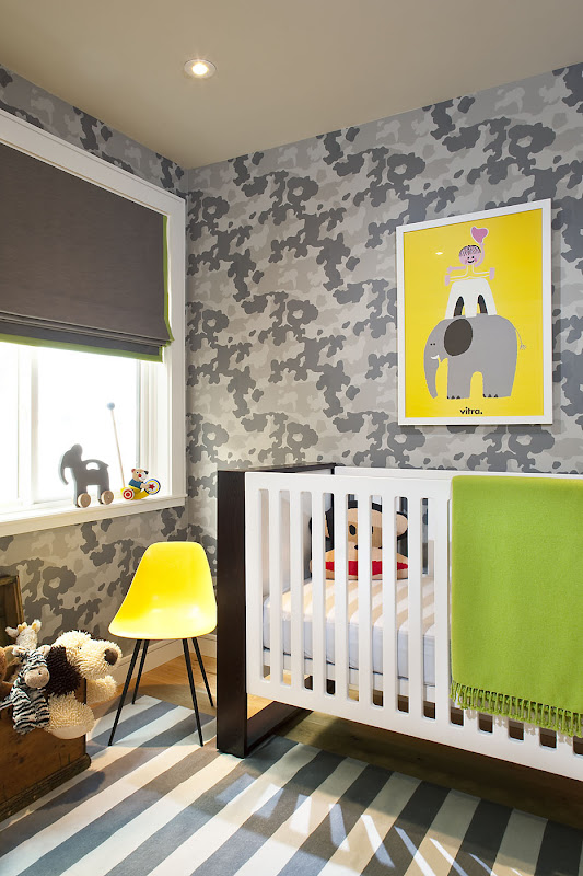 Baby room with floor to ceiling grey wallpaper, a blue and white striped rug, roman shades, a yellow Eames chair, a graphic dark wood and white crib and a bright picture of  child riding an elephant with a yellow background