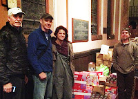 Mark provide food, cleaning supplies, and infant needs to many who were still in need of assistance from Hurricane. Photo of Mark two men and a woman next to relief supplies.