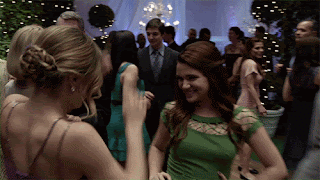 Duas garotas com vestido de festa dançando felizes uma com a outra