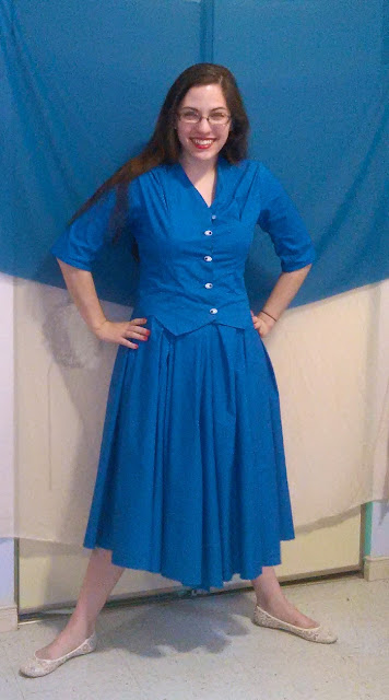 Colour photo of a young woman in a blue dress.