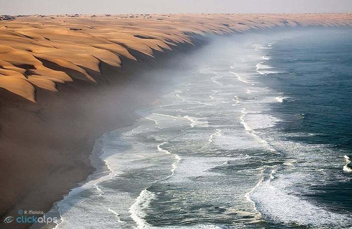 The Southern Namib desert is home to some of the tallest and most spectacular dunes of the world, ranging in color from pink to vivid orange. These dunes continue right to the edge of the Atlantic Ocean. The cold waters of the sea brushing against the dunes of the Namib desert is one of the most surreal sights.