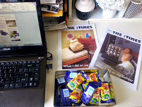 Laptop computer, a tin of Caramello Koalas and two sample covers of The tiny Times on a desk.