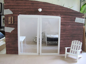 Dry fit of a dolls' house shed kit, with stained weatherboarding taped to the sides.