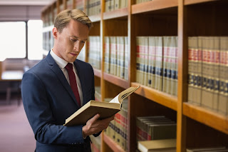 Legal knowledge and legal research is king in drink driving cases Attractive man studying a case report in a library