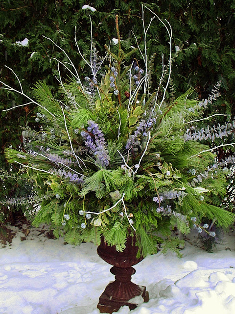 Winter pot with blue eucalyptus and white sticks by Chalet's Specialty Garden Care staff