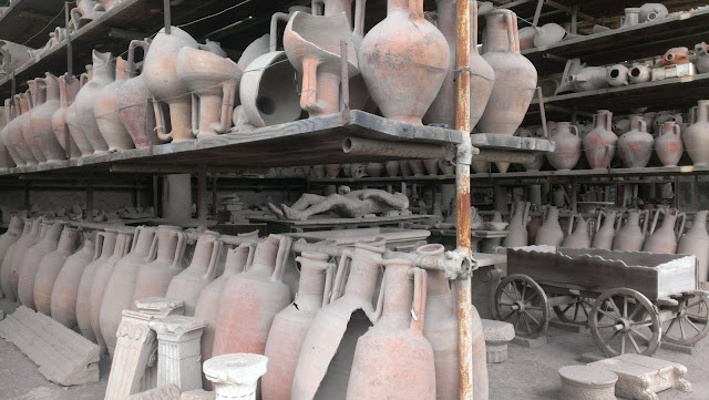 Pompeii artifacts. rows and rows of ceramic jugs, a cast of a petrified Pompeii resident and some marble pieces