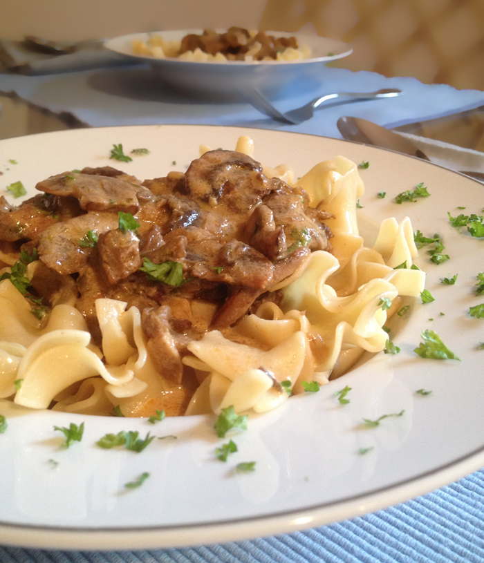 Image of Beef Stroganoff served in a white bowl over egg noodles
